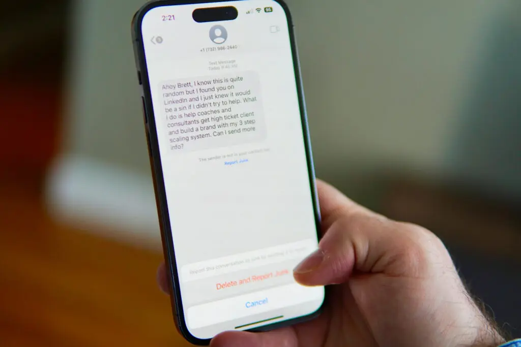 Hand holding a smartphone showing a text message conversation